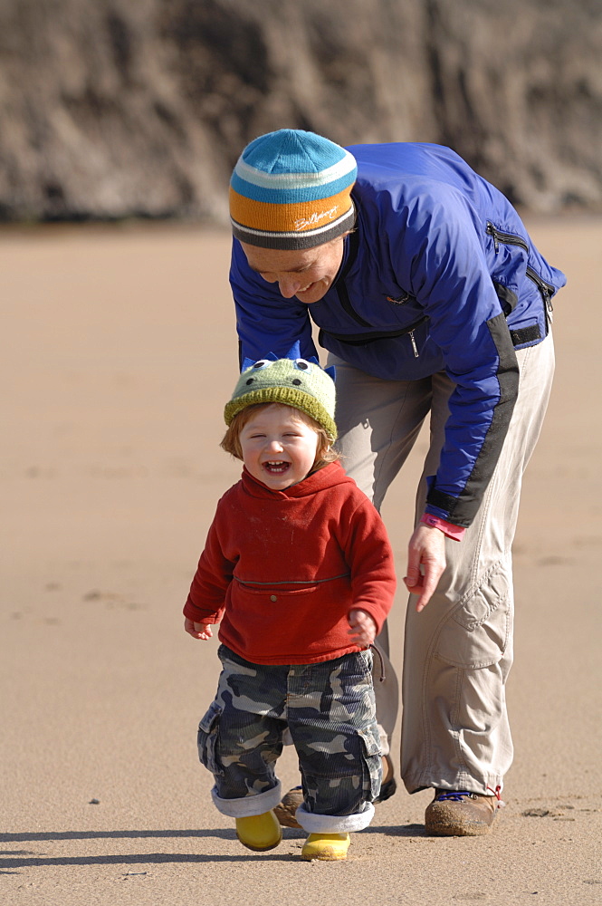 Mother and young son running on beach, Broad Haven South, Stackpole, Pembrokeshire, Wales, UK, Europe