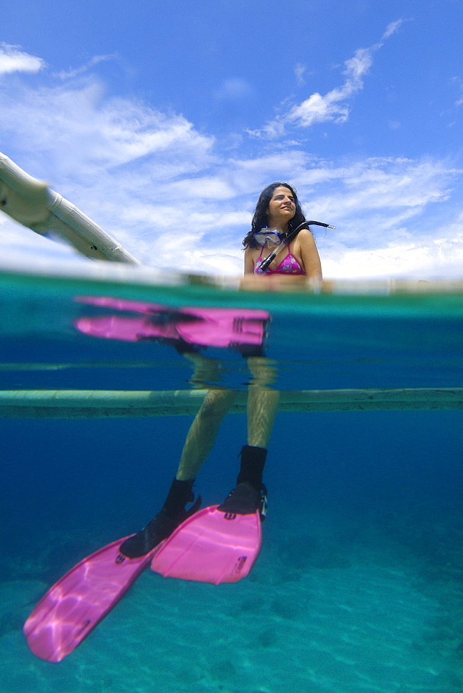 Snorkeller resting on the side of a banca (traditional Philippino vessel), Apo island Marine Reserve, Philippines, Southeast Asia, Asia