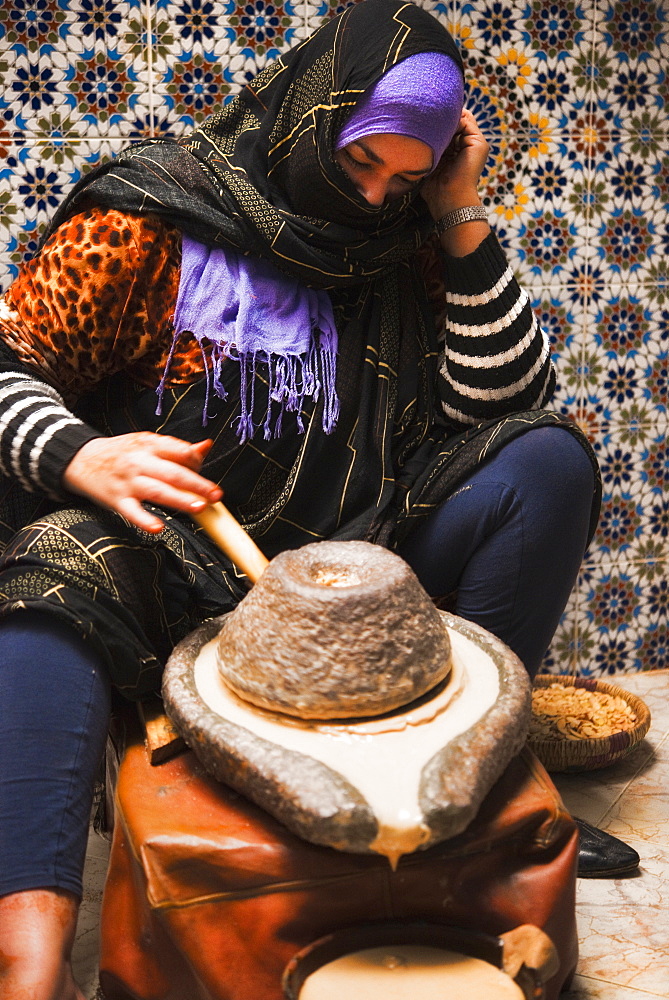 Argon / Argain Oil, considered to be one of the finest natural anti-ageing treatments for skin, traditional grinding of seeds, milling, muslim women. Taroudant, Souks, Agadir. Morocco