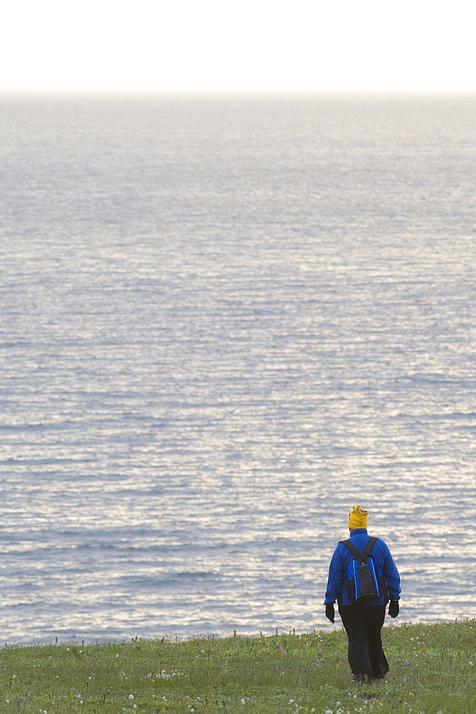 Tourist  Female hiker walking, exploration on Bering Islands (Bering Sea) Russia, Asia