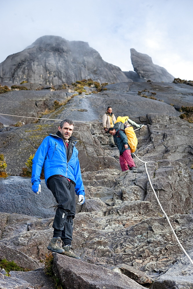 Tourists climbing down Mount Kinabalu.   Kinabalu National Park, Sabah, Borneo, Asia