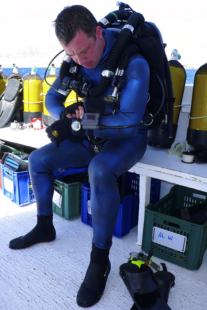 Diver on board dive boat checking equipment    (rr)