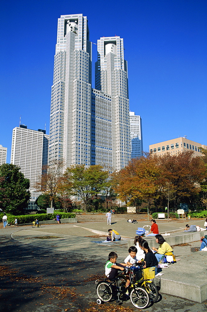 Children play in a park below the New Tokyo City Hall in Shinjuku, Tokyo, Japan, Asia