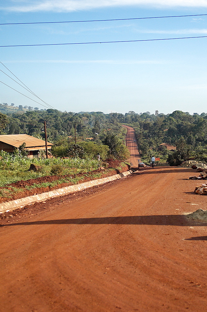 This bright red road clearly shows the type of soil abundant in this area and makes you appreciate why everything has a red hint of colour. Jinja, Uganda, East Africa