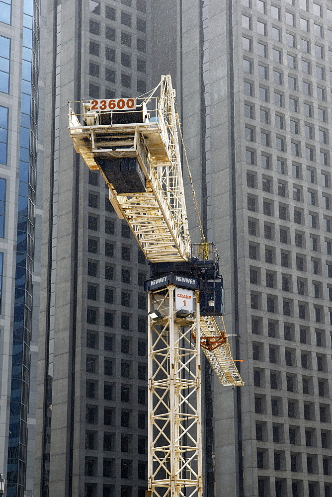 A Newway Crain at work in downtown Vancouver, Canada.  The yellow Crain really Stands out against a modern skyscraper background. Vanocuver, BC, Canada