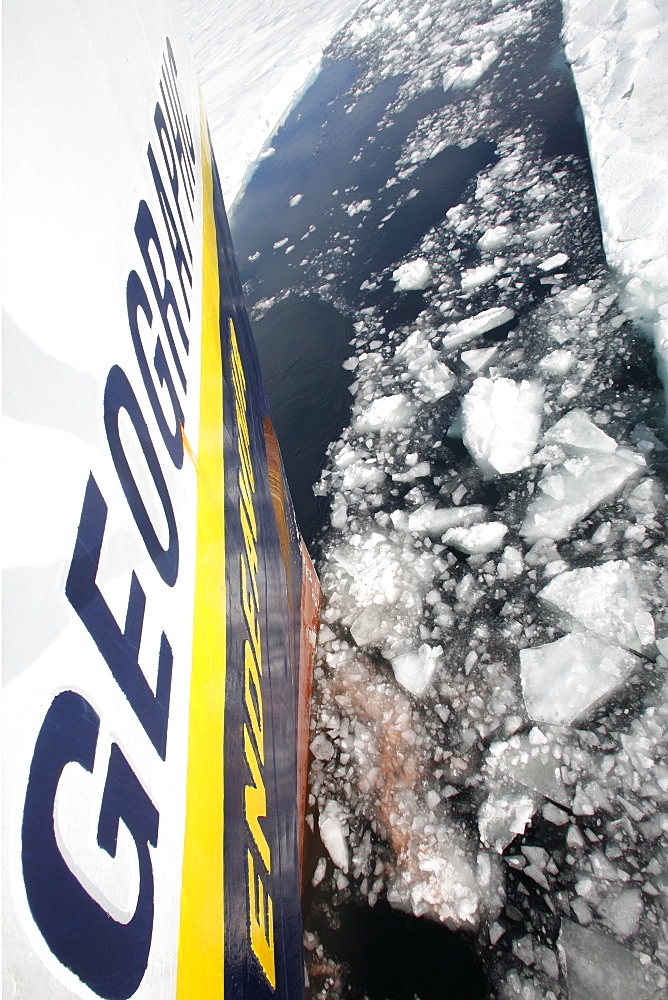 The National Geographic Endeavour breaking through new fast ice around the Antarctic Peninsula. Note the orange hull paint left on the ice where the bow has pushed through.