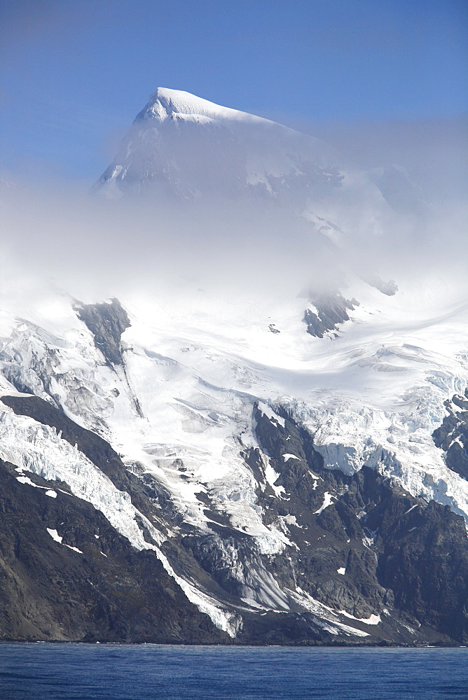 A view of the jagged peaks of Elephant Island shrouded in clouds in the South Shetland Island Group, Antarctica.