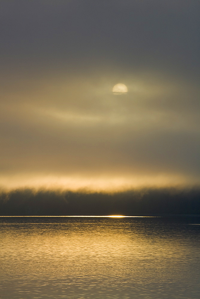 Sunrise on fog-shrouded Idaho Inlet, Southeast Alaska, USA. Pacific Ocean.