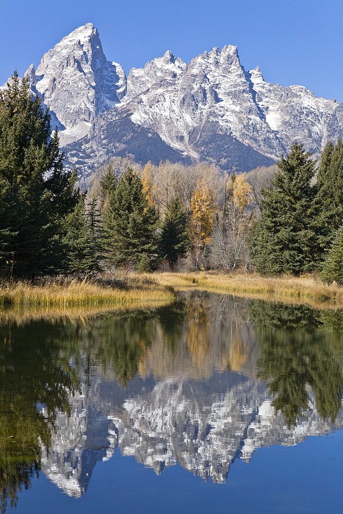 Reflected light on water from the Grand Teton Mountain Range, outside of Jackson Hole, Wyoming. This image was shot from the Schabawacker Landing on the snake river.