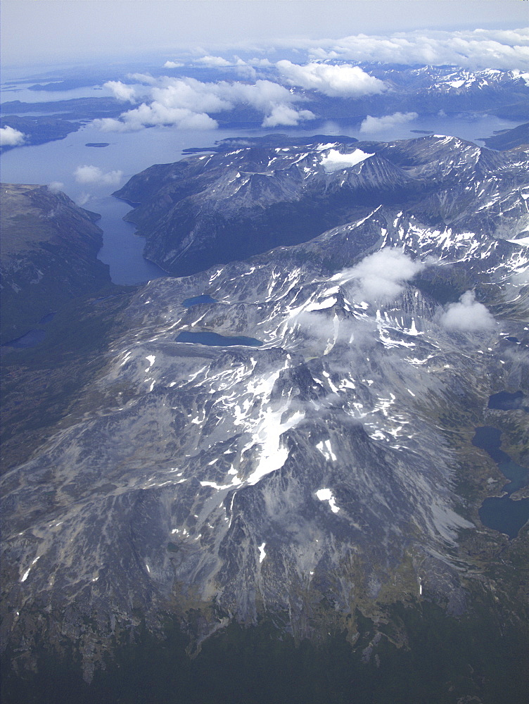 Aerial views of snow-capped mountains, ice fields, and glaciers on a charter flight from Santiago, Chile to Ushuaia, Argentina