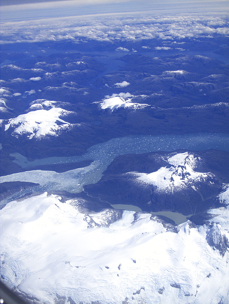 Aerial views of snow-capped mountains, ice fields, and glaciers on a charter flight from Santiago, Chile to Ushuaia, Argentina