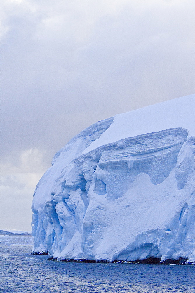 The Lindblad Expedition ship National Geographic Explorer transits Lemaire Channel in late evening light on the west side of the Antarctic peninsula in Antarctica