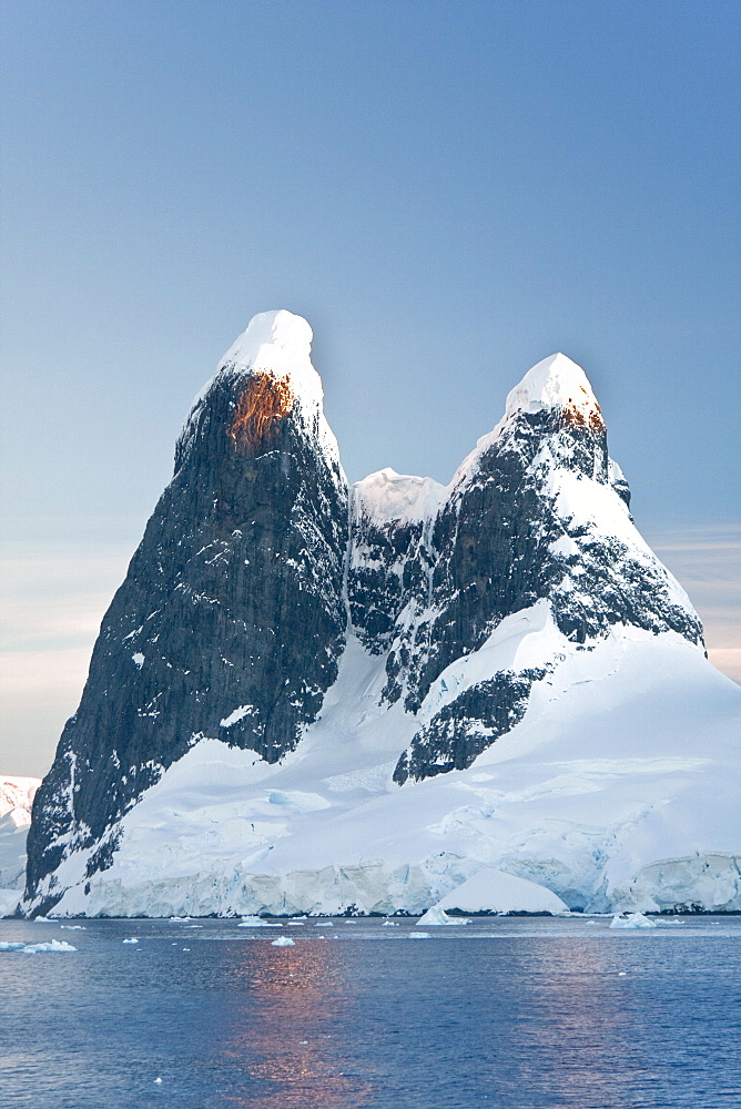 The Lindblad Expedition ship National Geographic Explorer transits Lemaire Channel in late evening light on the west side of the Antarctic peninsula in Antarctica