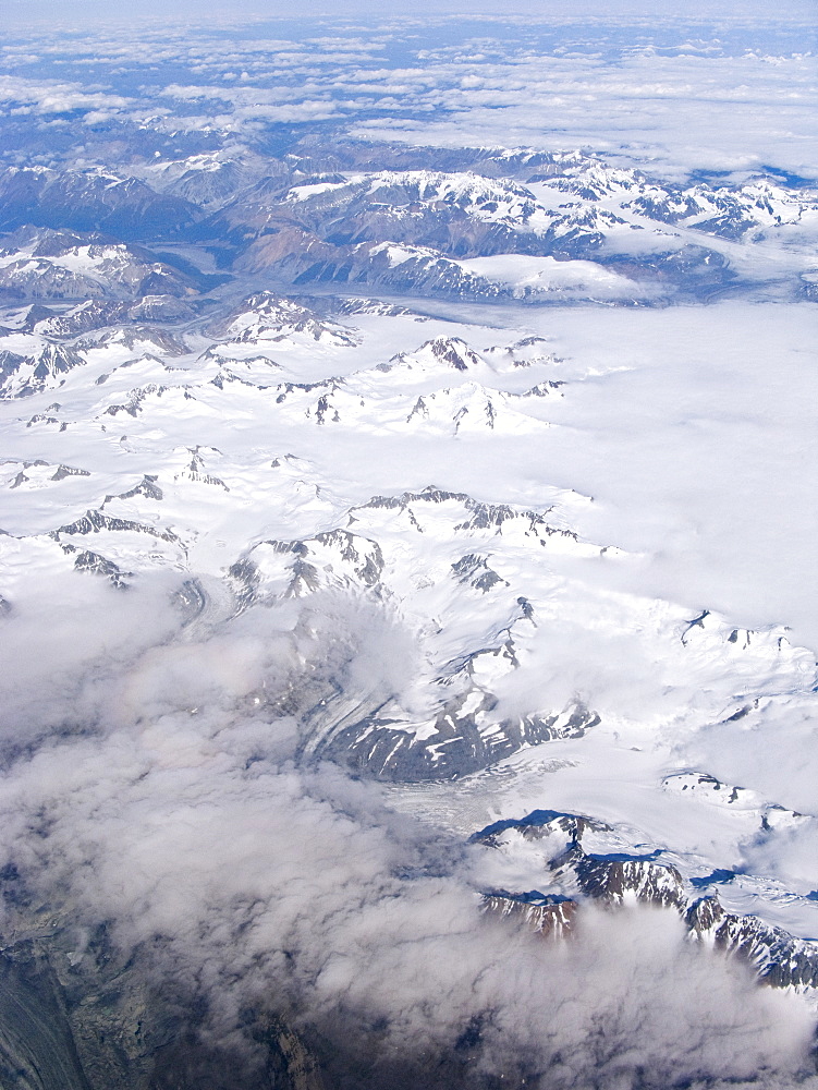 Aerial views of snow-capped mountains, ice fields, and glaciers on a commercial flight from Juneau to Anchorage Alaska, USA, Pacific Ocean