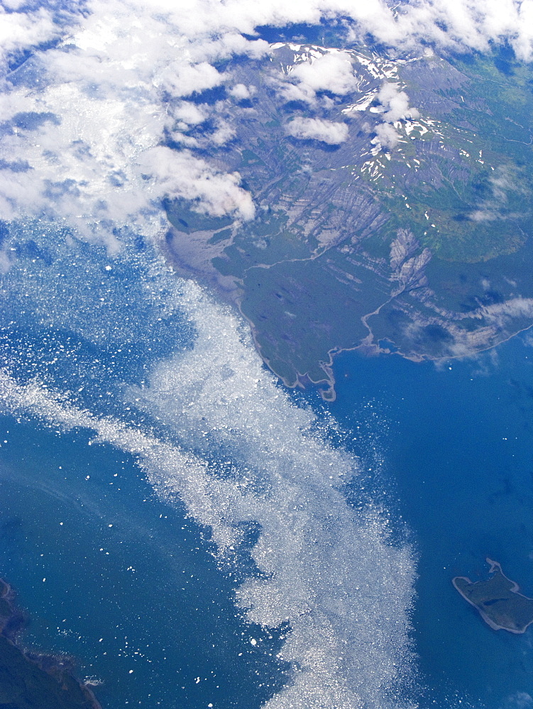 Aerial views of snow-capped mountains, ice fields, and glaciers on a commercial flight from Juneau to Anchorage Alaska, USA, Pacific Ocean