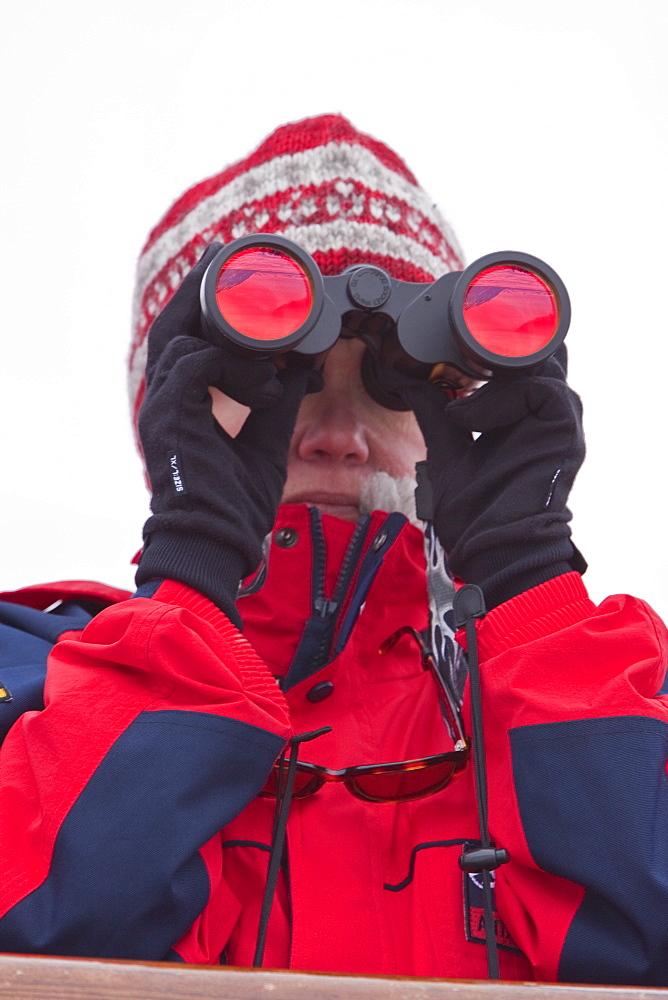 Guest from the Lindblad Expedition ship National Geographic Explorer scanning for polar bears around the Svalbard Archipelago in the summer months