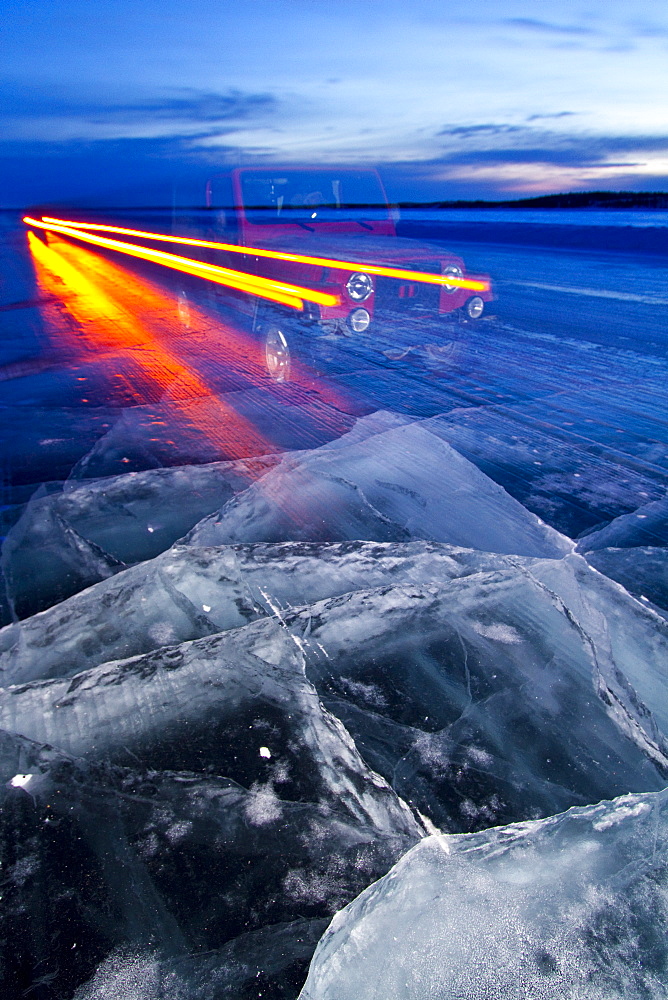 Long exposure camera times of a Jeep on the ice road from Tibbitt to Contwoyto beginning just outside of Yellowknife, Northwest Territories, Canada