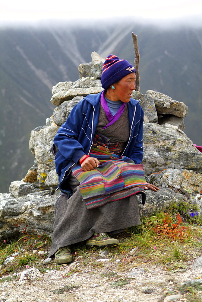 Tibetan Lady.  Mountain and Clouds.Traditional Dress,  Himalayas, Tibet.