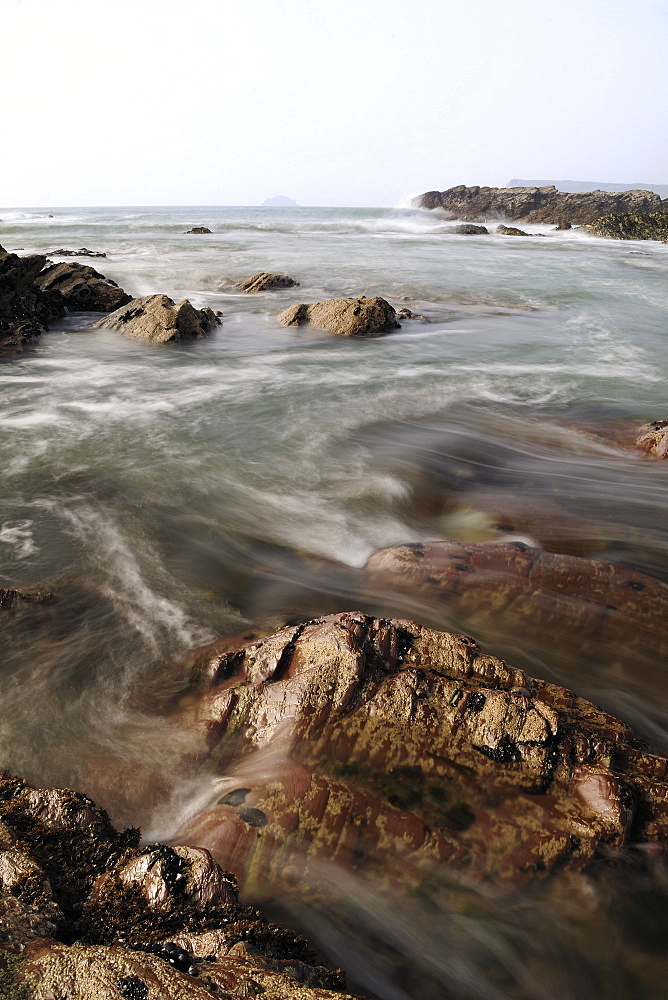 Sea swirling around rocks as tide rises, near Polzeath, Cornwall, England, United Kingdom, Europe