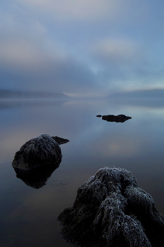 Loch Awe on a misty frosty morning, rocks in foreground, facing west.  Argyll, Scotland