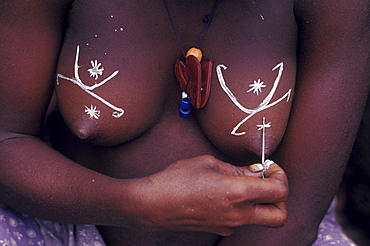 Republic of Congo (formerly Zaire) Ituri Forest. Pygmee girl decorates her breats.