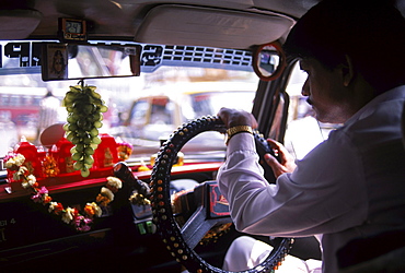 A taxi driver with his alter to insure safety is a common sight on Indian road