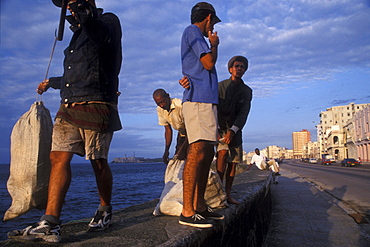 Fishermen prepare to set out in homemade rafts by climbing over the Malecon wall, Havana, Cuba