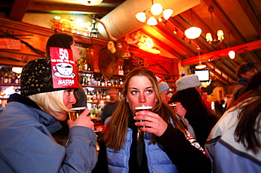 Kim Wackman and Molly Hutchinson drinking beer in bar during the Pub Crawl, an annual St. Patrick's Day festival in Breckenridge, Colorado.