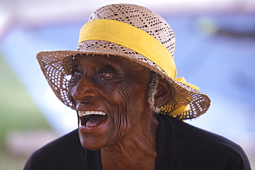 An elderly Bahamian woman shares a laugh with friends at her home on Cat Island in the Bahamas.