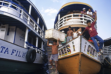 Brazilian workers unload rows of boats at the docks of the Amazon port city of Manaus.