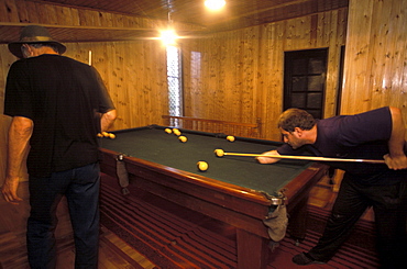 A young man who lost his hand in a land-mine accident, plays pool in a seaside home in Mayak, Abkhazia.