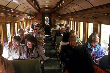 Riders on a coal-fired, steam-powered locomotive of the Durango & Silverton Narrow Gauge Railroad on the tracks between Durango and Silverton, Colorado