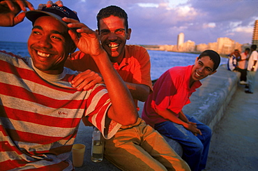 Laughter, music and rum frequently flow on the malecon, Havana, Cuba's main water front street where locals come to watch the sunset and socialize.