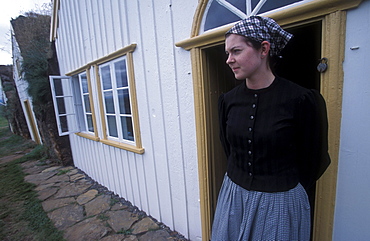 Museum employee in period costume in front of an historic turf building at Glaumbaer, northcentral Iceland. An important discovery was made in Glaumbaer in 2001: the homestead of Thorfinn Karlsefni, the father of the first European born in the New World. This find has important implications for Viking history.