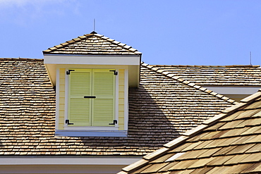 Rooftop of a building in Bahamas with brightly painted dormer.