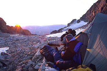 Two climbers wake at sunrise on the upper saddle during their ascent of the Grand Teton, Grand Teton National Park, Wyoming.