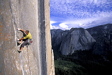 Tommy Caldwell on the head wall of the Dihedral Wall during his first ascent of the route on El Capitan in Yosemite National Park in the Sierra Nevada Mountains, California. He is crack climbing a 5.13 pitch. Half Dome is visible in the distance.