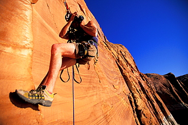 Craig Luebben negotiates his camera while climbing in Lake Powell, Utah.