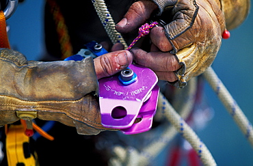 Bob Porter adjusts his wall hauler, a pully used to haul gear up a wall. Bob Porter is climbing Zodiac, a 16 pitch 5.11 A3+ route, in Yosemite National Park, California.