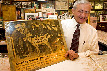 Sam Sianis poses in Chicago's landmark Billy Goat Tavern with a newspaper photograph of his uncle Sam Sianis and the famous goat that put the "Curse of the Billy Goat" on the Chicago Cubs baseball team.