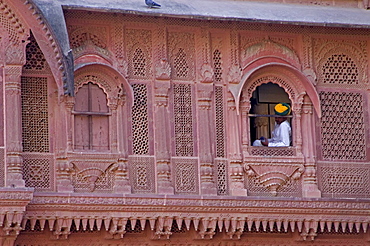 A guard looks out of a gilded window in the Mehrangharh Fort, Jodhpur, Rajasthan.