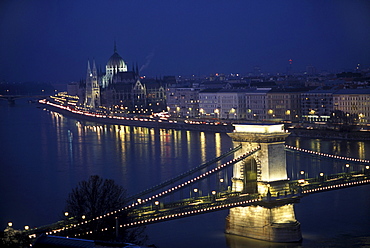 The Lanchid Bridge (also known as the Chain Bridge) spans the Danube River in Budapest, Hungary. The Parliment building rises in the background.