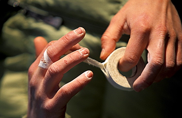 Joi Gallant tapes her tattered hands during a bouldering expedition in Patagonia outside of El Chalten, Argentina.