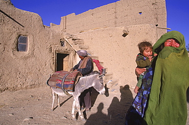 Striking Mongol features distinguish the face of a woman and her child (who is blind) living in the ruins of the Qala-i-Dokthar (Daughter's Castle), outside of the town of  Bamiyan, August 30, 2002.  Most of the old town was destroyed and up to 20,000 people of the region might have perished when Bamiyan fell to the Taliban in 2001.   Bamiyan Valley is located in the Hazarajat at the edge of the Koh-i-Baba range , the end of the Hindu Kush.  Bamiyan was a prosperous Buddhist kingdom on the ancient Silk Road until the 10th century, when the region  was converted to Islam; in the 12th century, it was destroyed by Ghengis Khan. Most of the people of this region are of the Hazara tribe, and are Shi'a Moslems who have been persecuted for centuries by many of the Pashtun rulers of Afghanistan, who are from the Sunni sect.  They most recently suffered at the hand of the Taliban, who tried for years to ethnically cleanse the region of its Shi'a people.