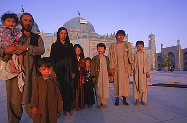 A large Turkomen family who have made a pilgrimage to the shrine of Hazrat Ali at the Blue Mosque in Mazar-i-Sharif, pose for a photo in front of the temple complex.  The Blue Mosque is considered to be one of the most important and beautiful buildings in Afghanistan