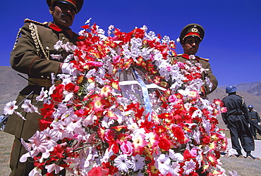 Elaborate flower wreaths are brought by Afghan soldiers as tokens of respect to  the shrine of Ahmad Shah Masood, on the one year anniversary of Masoods assasination, at a ceremony in the Panjshir Valley, Afghanistan, September 9, 2002. Masood was a revered mujahedin leader who fought the Soviets in the Afghan-Soviet war, and who also was one of the main leaders of the Northern Alliance which opposed the Taliban and helped the US Military in their defeat.  Masood was assasinated by what are thought to be Al Queda operatives on Sept. 9, 2001.  A shrine has been erected in the Panjshir  Valley, near the village of Bazarak, from where he led much of his resistance to both the Soviet and Taliban forces, to honor this latest of Afghan war heros.