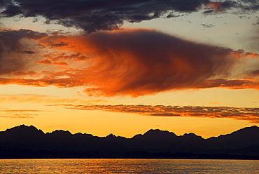 A sunset over the Sea of Cortez and the Sierra de Giganta on the Baja California mainland seen from a beach on Isla del Carmen. Baja California, Mexico.