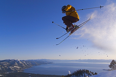 A man jumping on skis above Lake Tahoe in California.