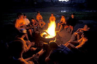 Boy Scout troop  sits around a campfire while camping on the Upper Missouri River in Montana.