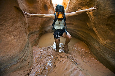 A woman hiking through mud in canyon, Utah.